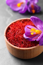 Dried saffron and crocus flower on grey table, closeup