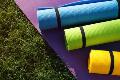 Bright exercise mats on fresh green grass outdoors, above view