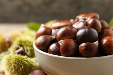 Fresh sweet edible chestnuts in bowl, closeup