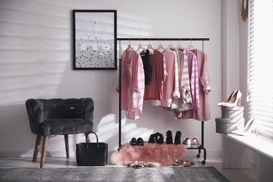 Dressing room interior with clothing rack and comfortable chair