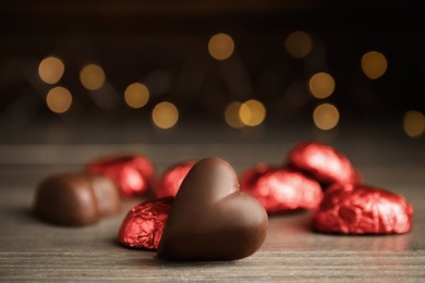 Tasty heart shaped chocolate candy on wooden table, closeup. Happy Valentine's day