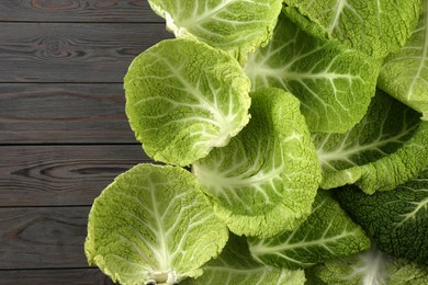 Photo of Fresh Savoy cabbage leaves on grey wooden table, flat lay