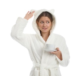 Young woman in bathrobe with cup of beverage on white background