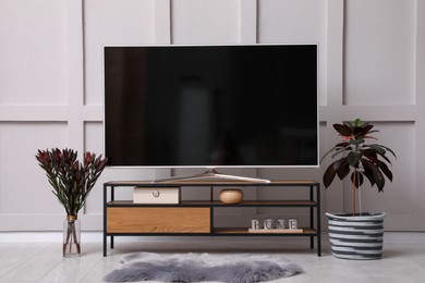 Stylish room interior with TV on wooden cabinet