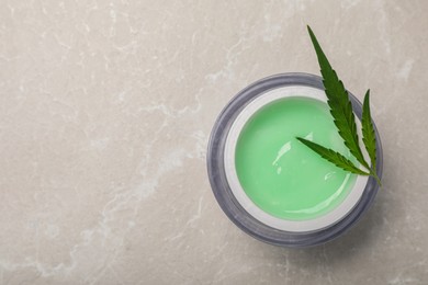 Jar of hemp cream and leaf on light table, top view with space for text. Natural cosmetics