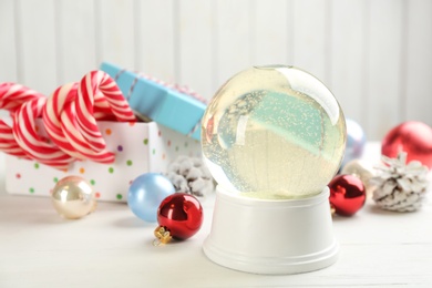 Beautiful Christmas snow globe and festive decor on white table