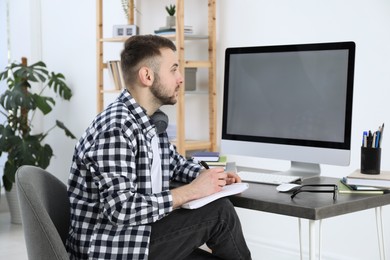 Young man using modern computer for studying at home. Distance learning