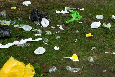 Different garbage scattered on green grass outdoors