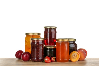 Jars of pickled fruits and jams on wooden table