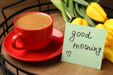Beautiful yellow tulips, cup of aromatic coffee and Good Morning note on wooden tray