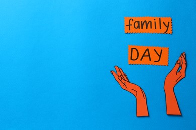 Photo of Cards with phrase Family Day and paper hands on light blue background, flat lay. Space for text