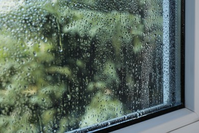 Window glass with drops of condensate indoors, closeup