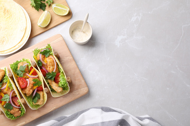 Yummy fish tacos served on marble table, flat lay. Space for text