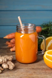Freshly made carrot smoothie in mason jar and ingredients on wooden table