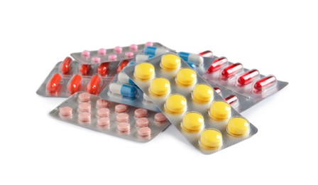 Blisters with different pills on white background
