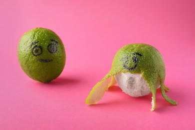 Limes with drawn faces on pink background. Exhibitionist concept