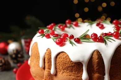 Traditional Christmas cake decorated with glaze, pomegranate seeds, cranberries and rosemary, closeup. Space for text
