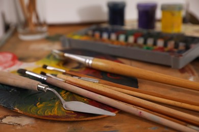 Spatula and brushes on wooden table, closeup
