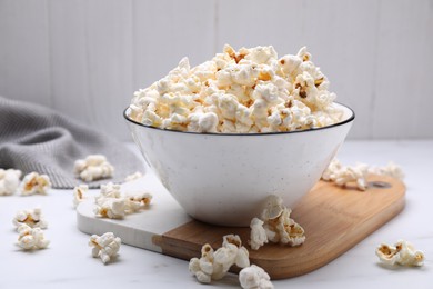 Photo of Bowl of tasty popcorn on white table