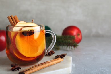 Aromatic hot mulled cider on light grey marble table. Space for text