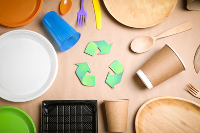 Recycling symbol, plastic, paper and wooden utensil on beige background, flat lay
