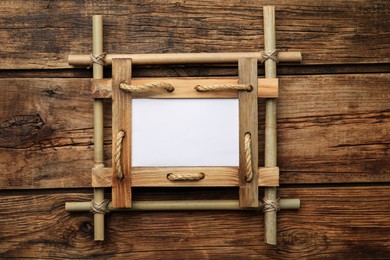 Empty bamboo frame on wooden table, top view