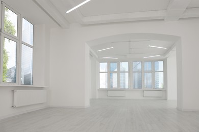 Empty office room with white walls, clean windows and modern lights on ceiling. Interior design