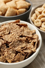 Different breakfast cereals in bowls on table, closeup