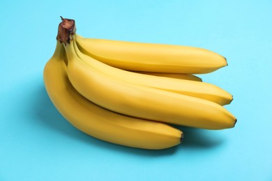 Bunch of ripe yellow bananas on turquoise background