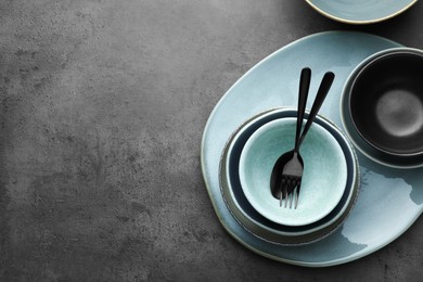 Photo of Stylish empty dishware and cutlery on grey table, flat lay. Space for text