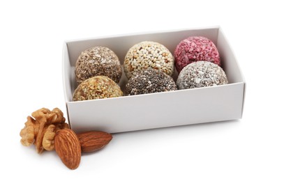 Different delicious vegan candy balls in box and nuts on white background