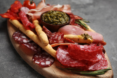 Photo of Tasty ham and other delicacies served on grey table, closeup