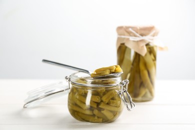 Canned green beans on white wooden table