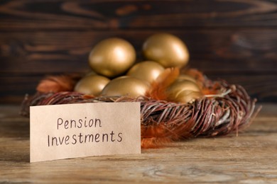 Many golden eggs and card with phrase Pension Investments on wooden table, space for text