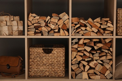 Shelving unit with stacked firewood, closeup. Idea for interior design