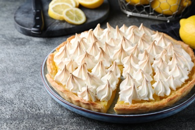 Cut delicious lemon meringue pie on grey table, closeup