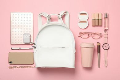 Stylish urban backpack and different items on pink background, flat lay