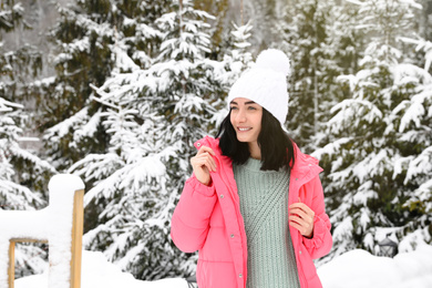 Happy woman near snowy trees. Winter vacation