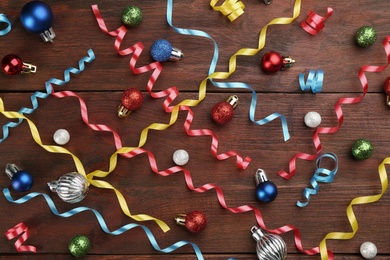 Flat lay composition with serpentine streamers and Christmas ornaments on wooden background