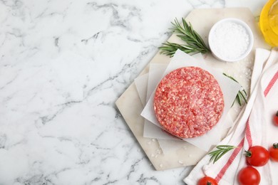 Raw hamburger patties with rosemary, salt and tomatoes on white marble table, flat lay. Space for text