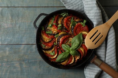 Photo of Delicious ratatouille on light blue wooden table, top view. Space for text