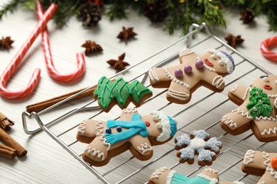Photo of Making homemade Christmas cookies. Gingerbread people and festive decor on white wooden table