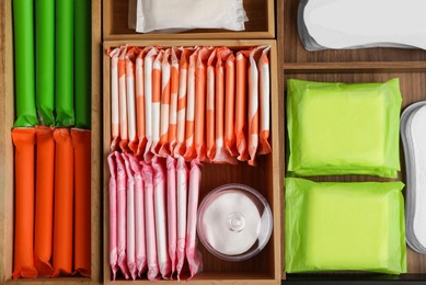 Storage of different feminine hygiene products in wooden organizers, top view