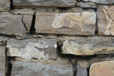 Photo of Wall with different stone fragments as background, closeup