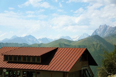 View of building and mountains under bright cloudy sky