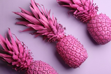 Pink pineapples on light background, flat lay. Creative concept