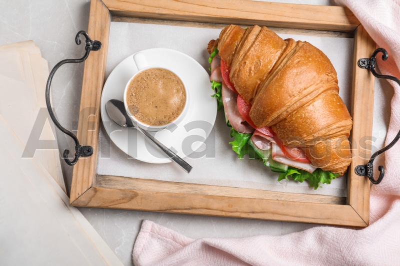 Tasty croissant sandwich and coffee on light grey marble table, flat lay