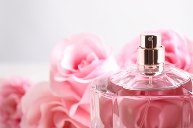 Bottle of perfume on blurred background, closeup. Space for text