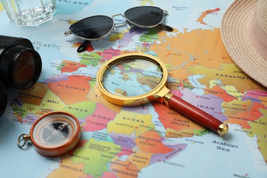 Different travel accessories on world map, closeup. Planning summer vacation trip