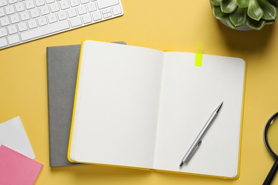 Photo of Flat lay composition with stylish notebooks on yellow background